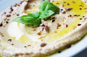 hummus with olive oil, basil. and seeds as garnishes