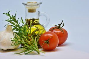 bottle of olive oil with garlic, tomatoes, and herbs