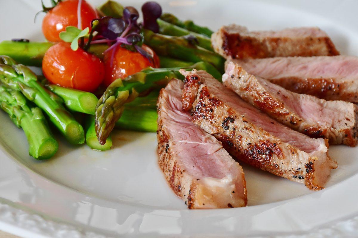 rare meat with asparagus, tomatoes, and microgreens