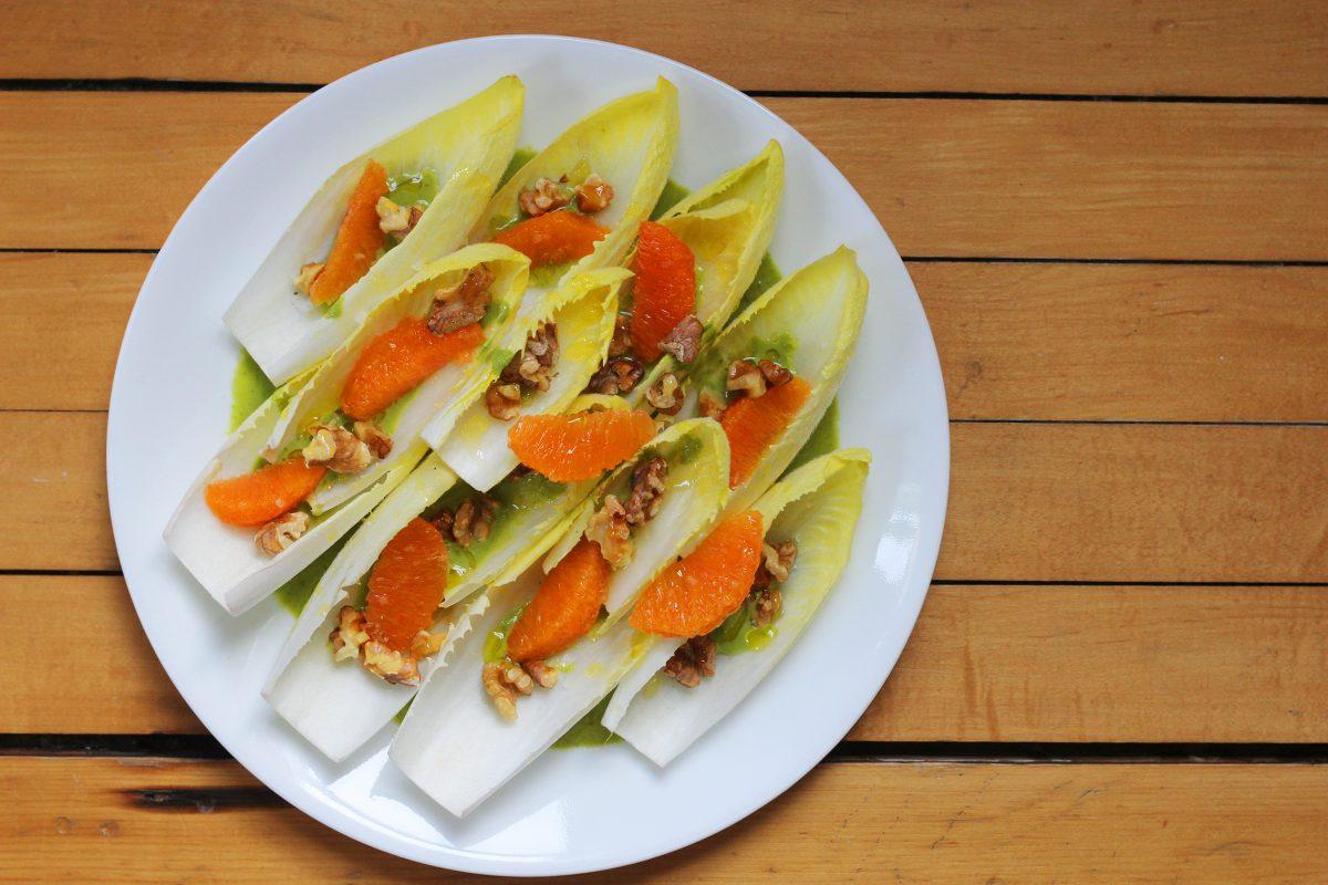 Endive leaves topped with cara cara orange segments and toasted walnuts