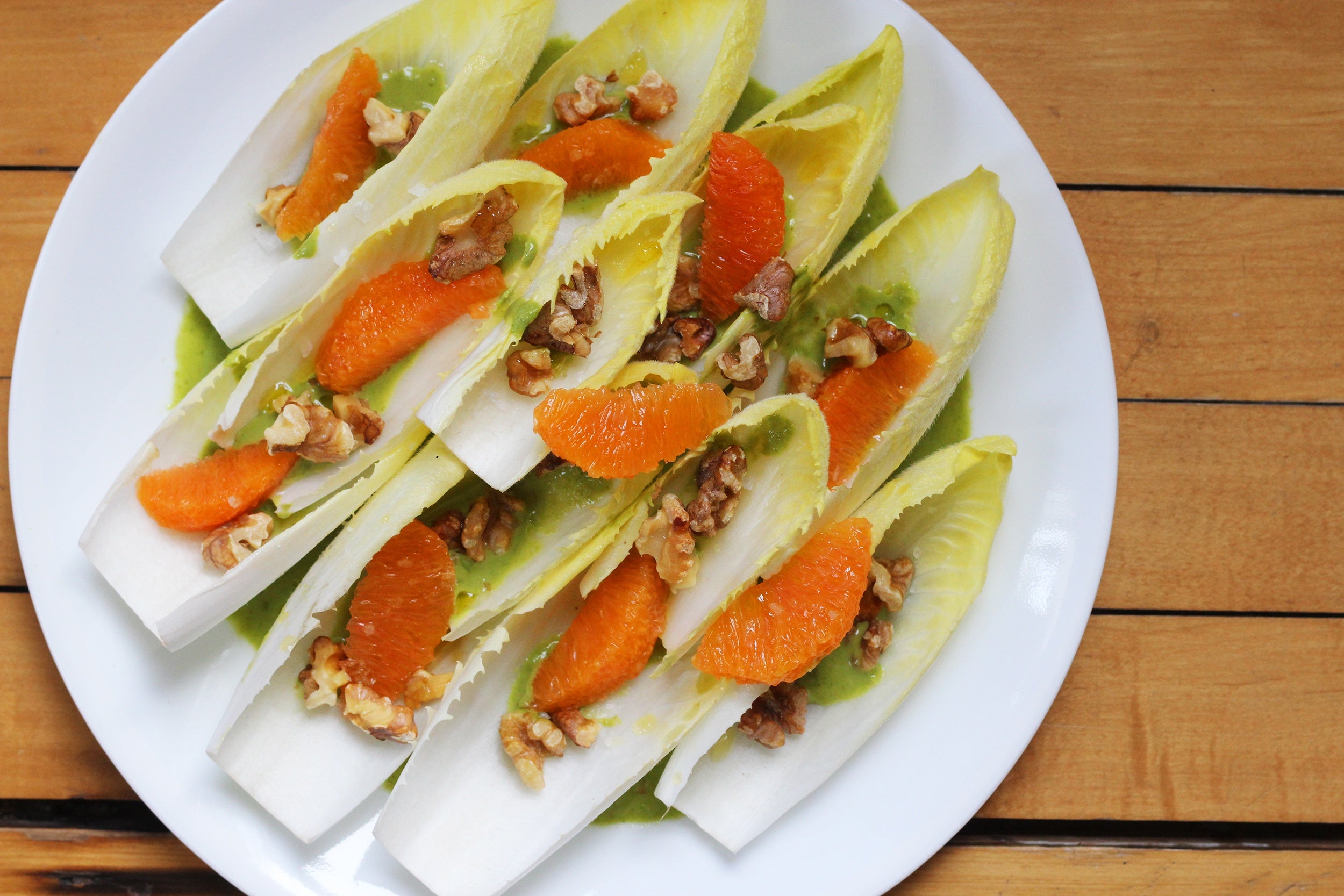 Endive leaves topped with cara cara orange segments and toasted walnuts