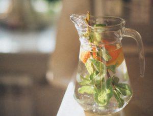 Pitcher of water filled with orange slices and mint leaves