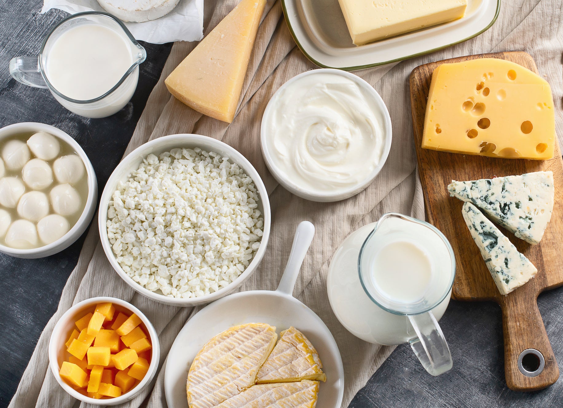 A variety of dairy foods including milk, yogurt and various cheeses including cheddar, swiss, blue cheese, mozzarella, brie