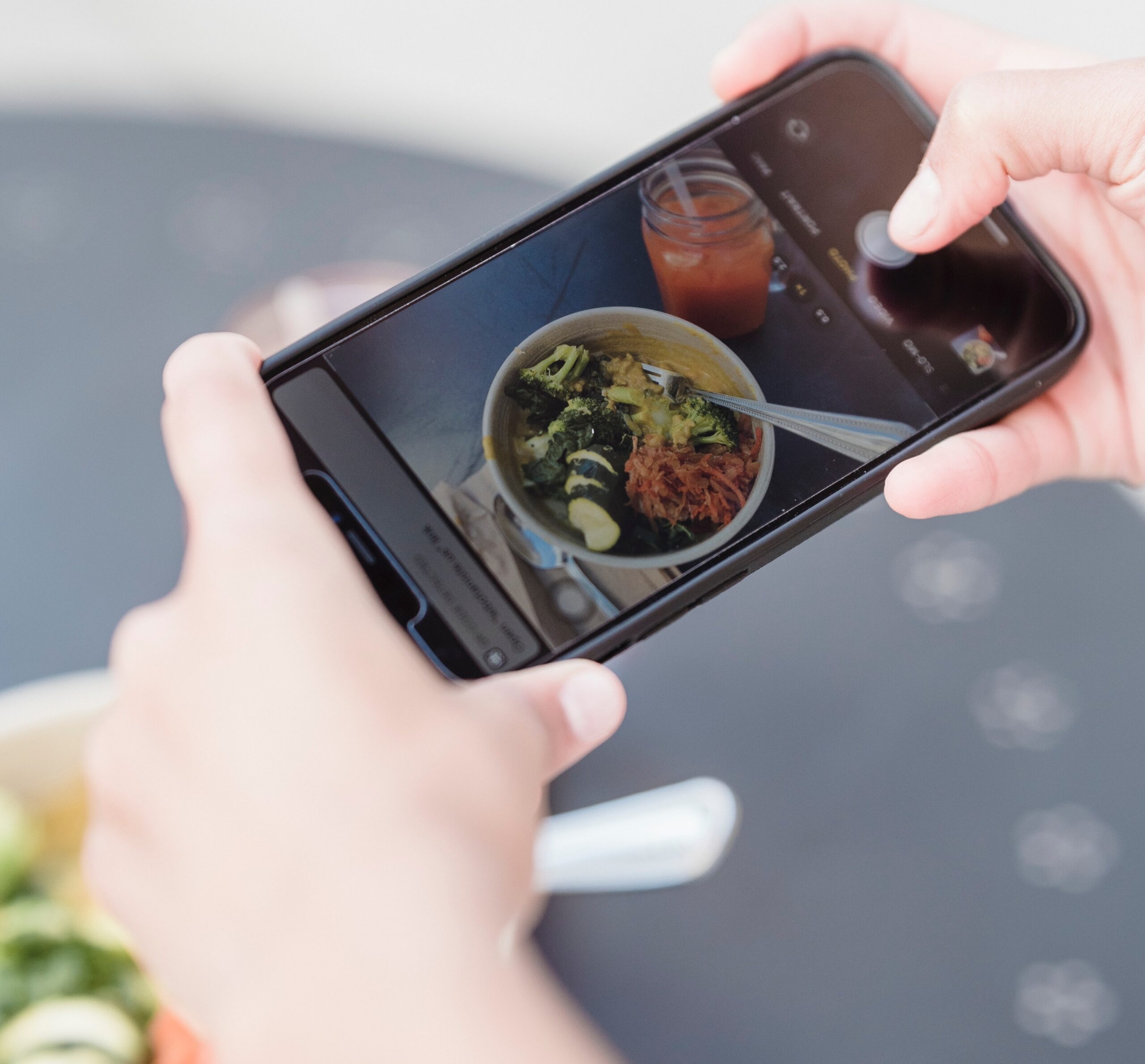 person taking a photo of a bowl of food with a smartphone