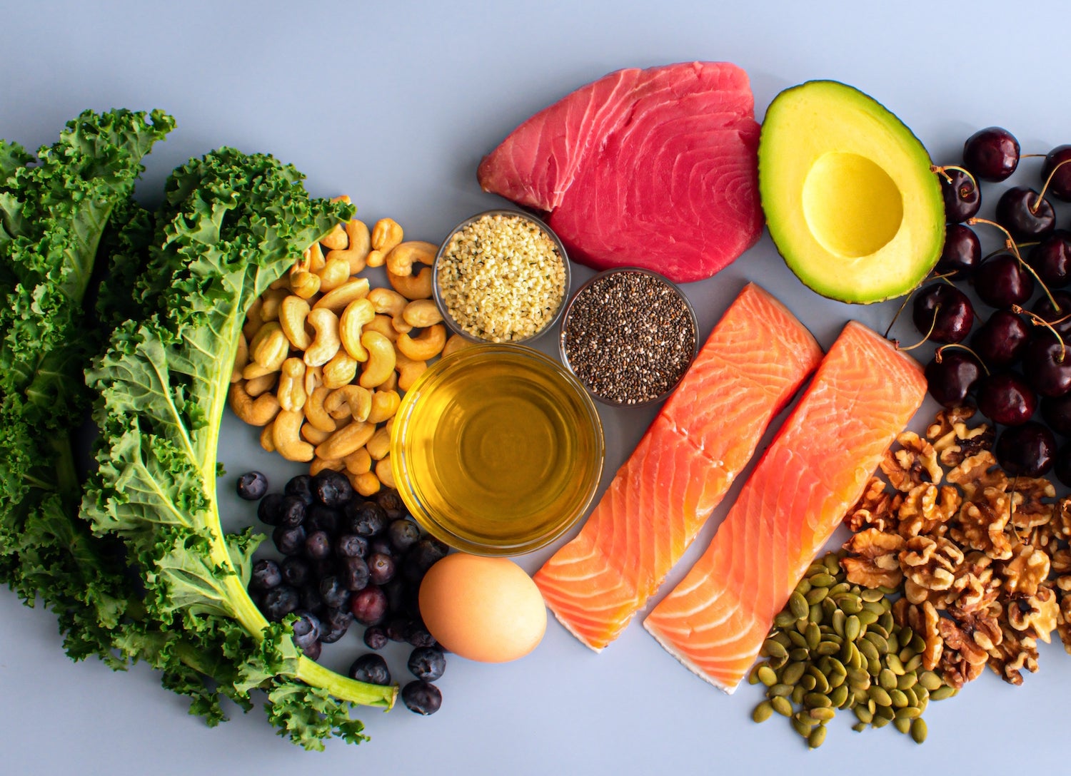 Overhead View of Fresh Omega-3 Rich Foods: A variety of healthy foods like fish, nuts, seeds, fruit, vegetables, and oil