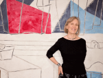 Claudia Goldin standing in front of Abstract Art
