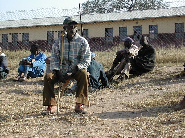 Older man in South Africa sitting in a field