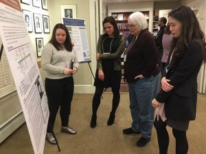 Mary Waters and research staff look at a poster