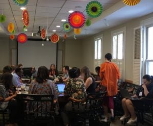 Colorful decorations hang from the ceiling in conference room as people gather