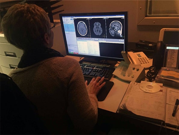 Technician reviewing scans of a brain MRI