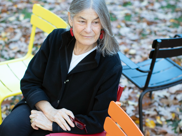 Lisa Berkman sitting in Harvard Yard with colorful chairs