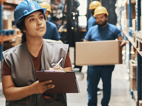 Woman in warehouse with clipboard