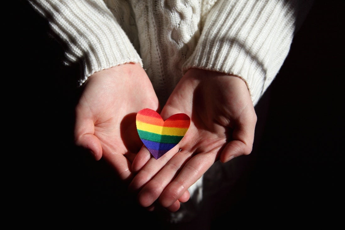 Closeup of hands holding rainbow heart