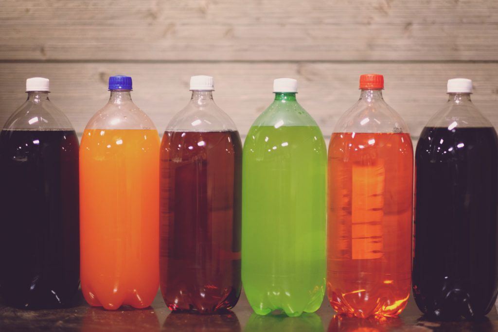 Large, different-colored bottles of soda and sugary drinks
