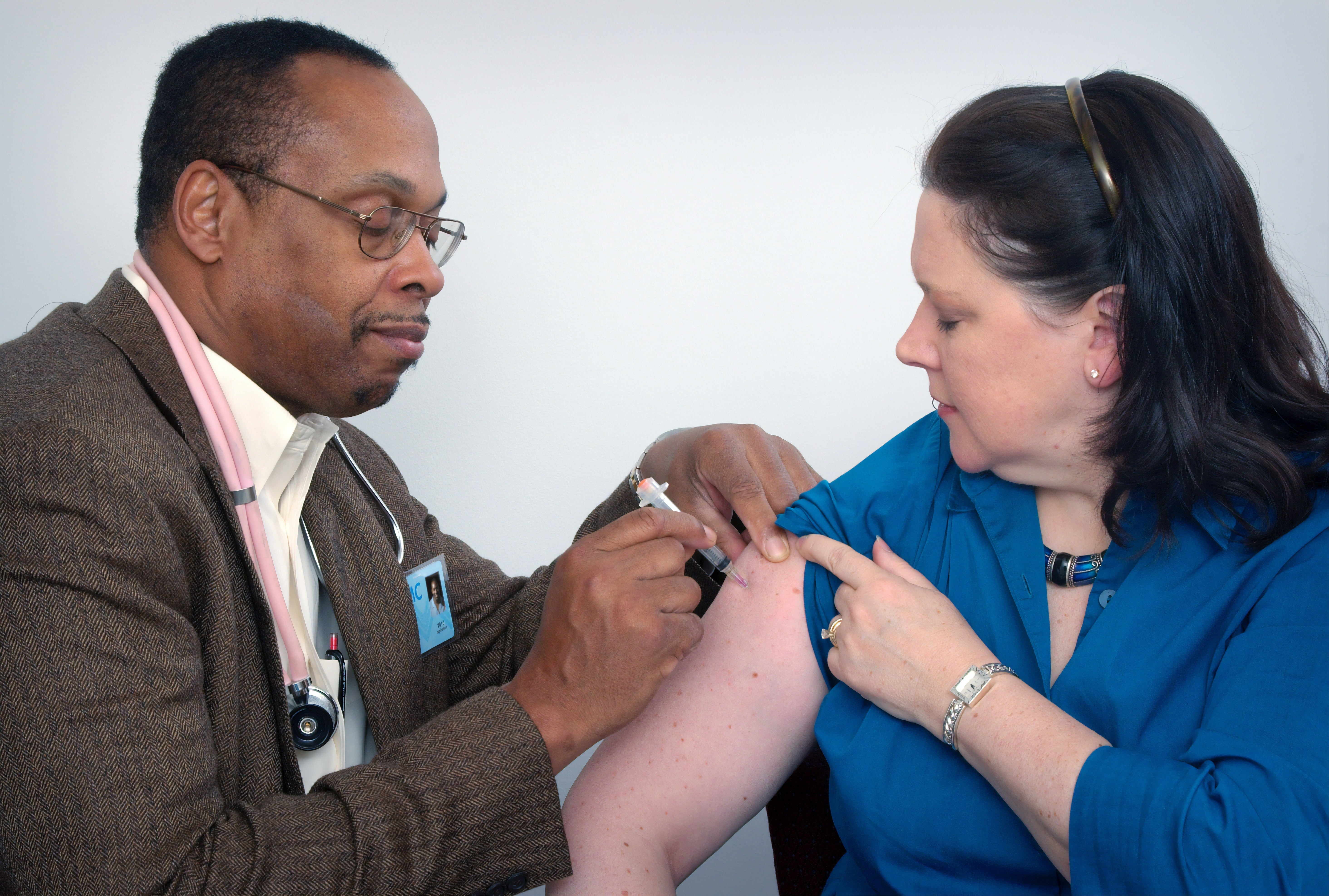 Doctor administering COVID-19 vaccine to patient