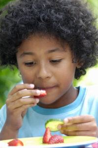 Young boy eating fruits and veggies