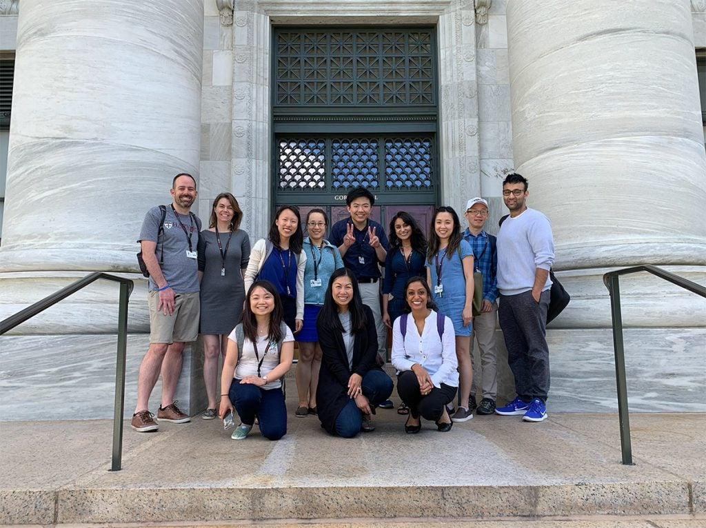 A group of students smile for the camera outside Harvard Medical School's Gordon Hall