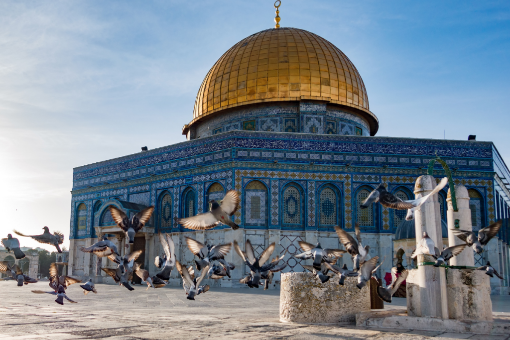 Flock of pigeons taking off in front of Dome of the Rock in Jerusalem.