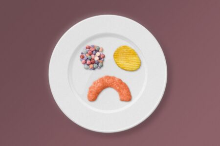 Graphic of a plate with potato chip, candy and cheeto making a sad face