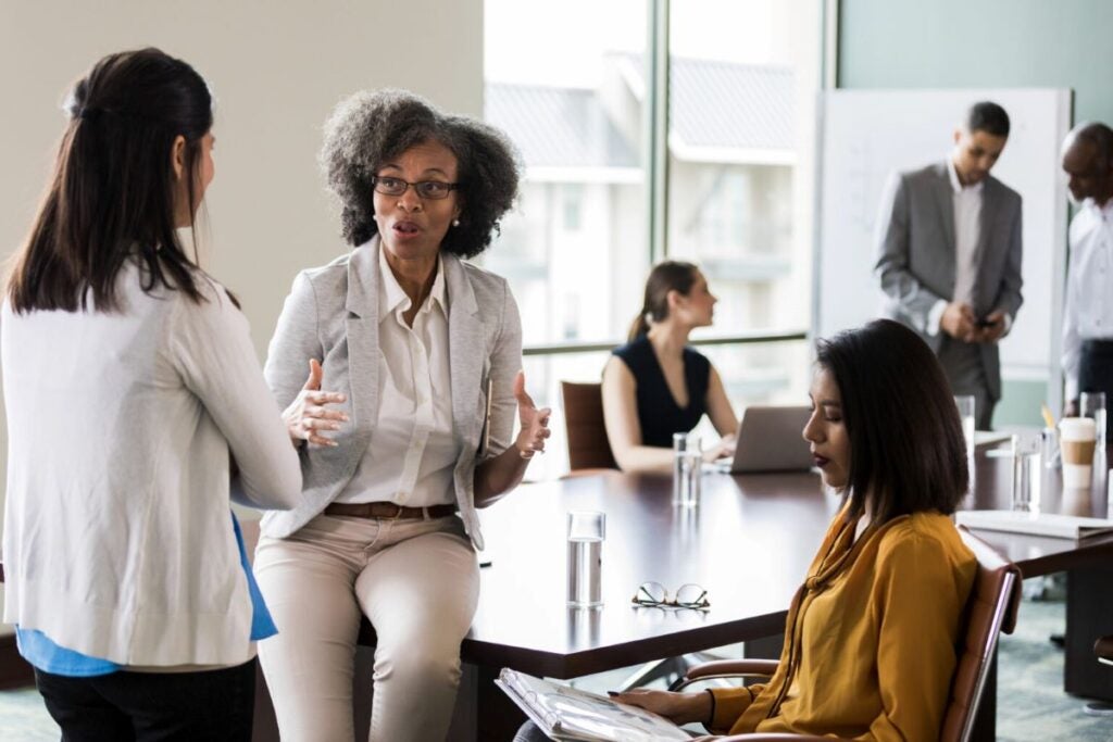 Women executives in a board room talking
