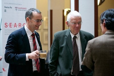 (L-R) Felix Moesner, consul, director, Swissnex Boston, and Joseph Brain chat with Frank Hu at the conference.
