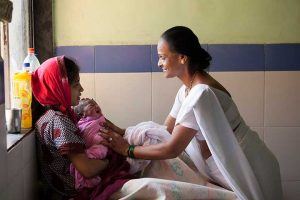 Woman helping woman and newborn; Kiran Thejaswi/Jhpiego, 2014