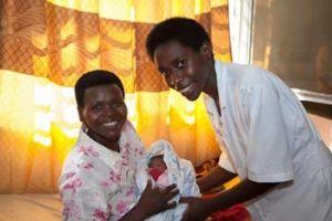 In the postpartum room of Nzige Health Center in Rwanda, a mother and newborn are attended by an MCSP-trained midwife. (Courtesy of Jhpiego/Guido Dingemans)