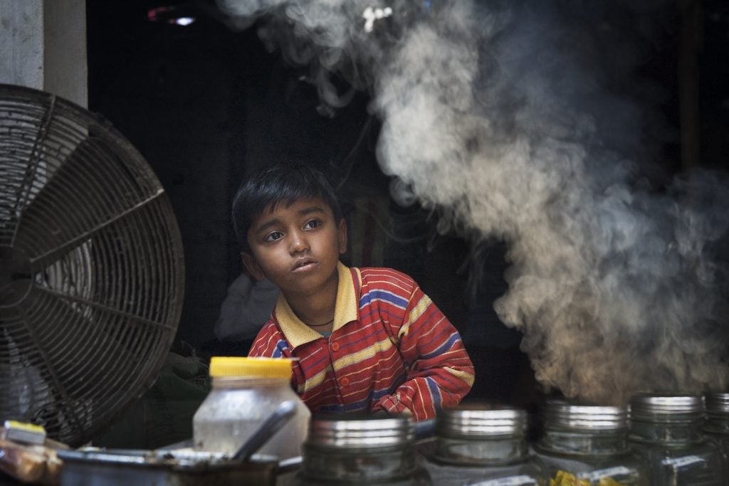 Young street vendor with smoke, Varanasi Benares India