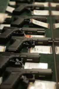 Guns are seen inside a display case at the Cabela's store in Fort Worth, Texas June 26, 2008. Individual Americans have a right to own guns, the Supreme Court ruled on Thursday for the first time in history, striking down a strict gun control law in the U.S. capital. REUTERS/Jessica Rinaldi (UNITED STATES) - RTX7DP7